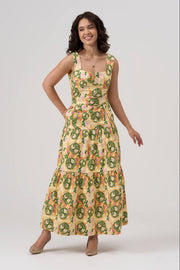 Woman wearing a floral tiered maxi dress on a white background