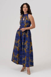 Woman wearing a blue and gold patterned dress on a white background
