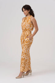 Woman wearing a yellow floral jumpsuit on a white background