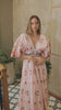 Woman wearing a pink floral maxi dress on a white background